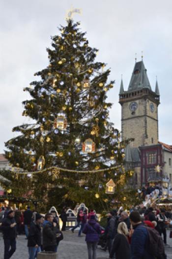 A Christmas market scene in Prague, Czechia, with the Old Town Hall in the background.