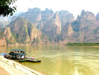 Binglingsi Shiku, aka Thousand Buddha Caves, with sandstone peaks rising above the Liujiaxia Reservoir.