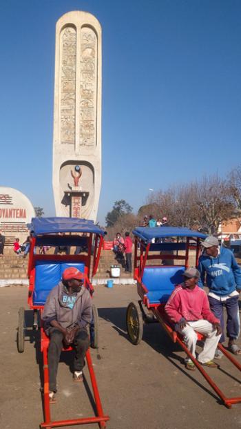 Rickshaw drivers on the ready in front of the Fahaleovantena Tribes Monument in Antsirabe, Madagascar.