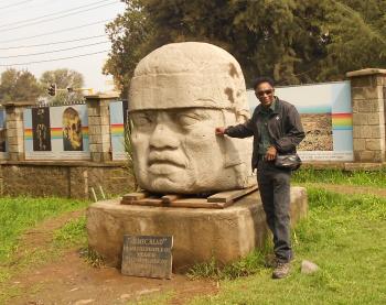 Frank Stewart at the replica of a giant Olmec stone head given to “the people of Ethiopia” in 2010 by “the people of Mexico,” as stated on the plaque in front.