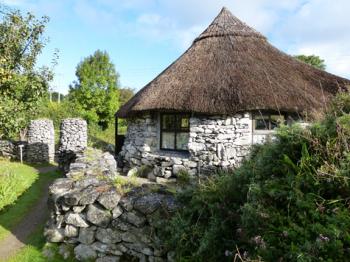 A reconstruction of an Iron Age roundhouse centers the seasonal gardens within Brigit's Garden — County Galway, Ireland. 