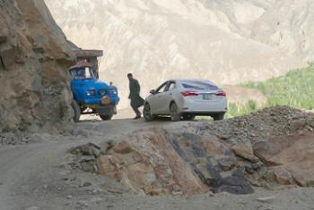 We waited while a truck and a car edged past each other on a hairpin curve on a one-lane road with no railing — Chitrāl district, northern Pakistan.