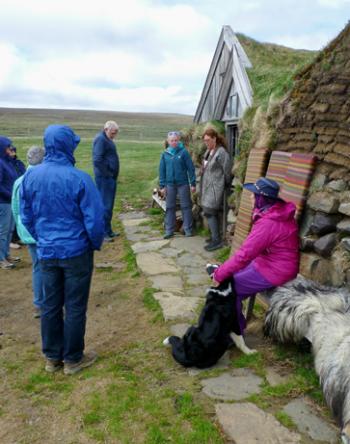 Visitors inspecting a historic traditional farm building on the north coast of Iceland. Photo by Randy Keck