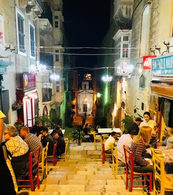 Street dining in Valletta featured restaurants with tables set up on wide staircases serving pizza, cheese platters and wine.