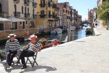 Two Gondola Men People talking in Venice Canal Street. Photo by Dreamstime/TNS