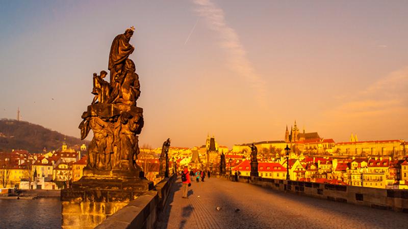 Statues of Charles Bridge, with Prague Castle in the background, at sunrise — Prague, Czech Republic. Photo: Dreamstime/TNS